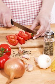 closeup of hands cutting tomatoes for italian food