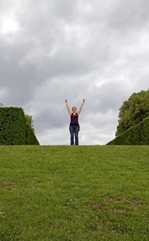 young woman with arms raised, shining moment