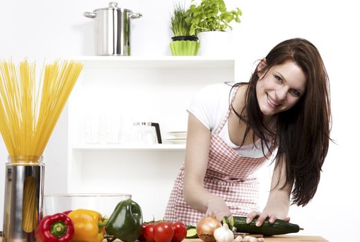 happy woman chopping cucumber for her salad