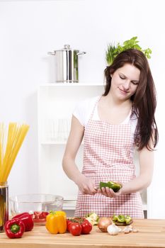 young happy woman preparing green paprika for salad