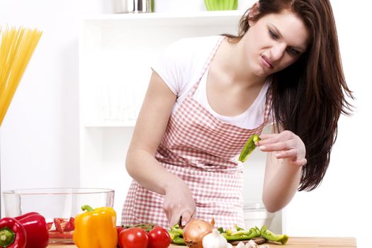 young woman is suspicious about the paprika she was chopping