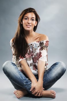 young woman wearing blue jeans sitting on the floor in taylor seat