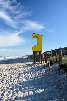 A yellow life gaurd station along the beach