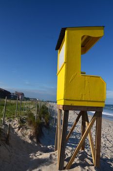 A big yellow lifeguard shack along the beach