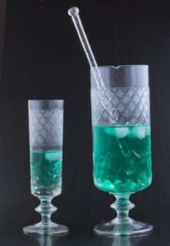 Glasses of water and mint over black background