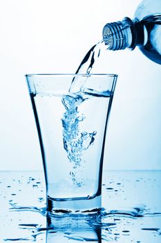 pure water splashing from bottle into glass