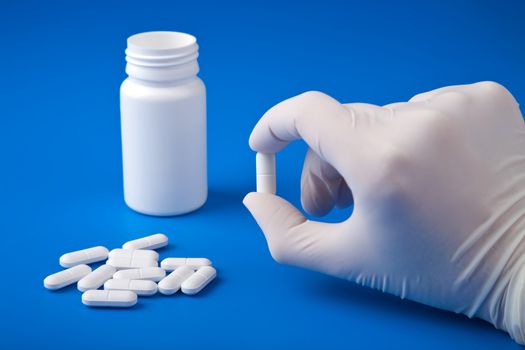 hand holding white pill