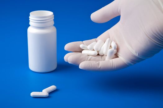 hand holding white pills