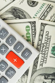 dollars and calculator with plus red button
