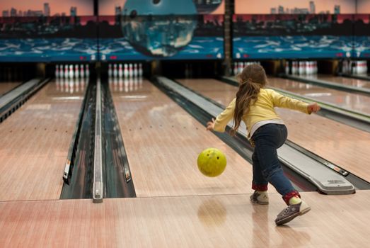 young girl playing in a bowling alley