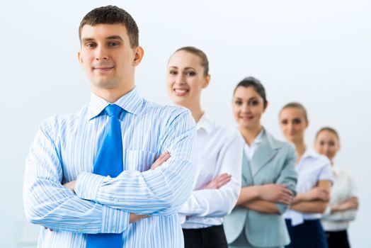 group of business people standing in a row, smiling and crossing his arms