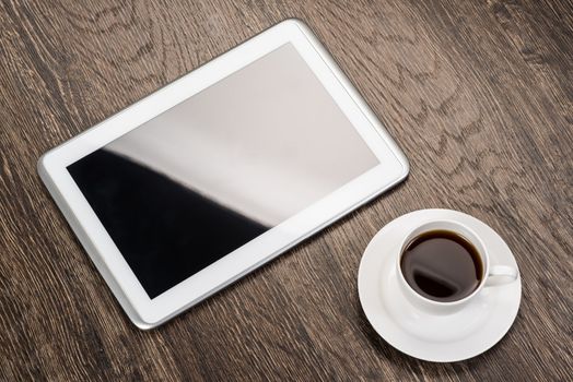 tablet and cup of coffee are on the table, still life