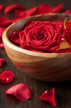 red roses in wooden bowl 