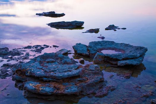 stones in sea at sunset