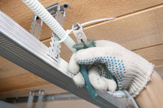 The builder lays the electrical wiring on the ceiling