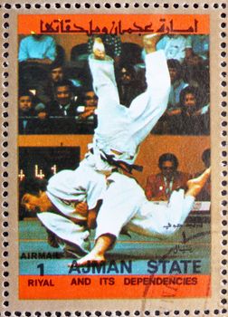 AJMAN - CIRCA 1973: a stamp printed in the Ajman shows Judo, Olympic sports, circa 1973