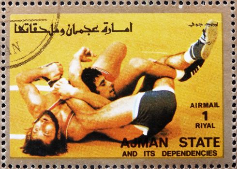AJMAN - CIRCA 1973: a stamp printed in the Ajman shows Wrestling, Olympic sports, circa 1973