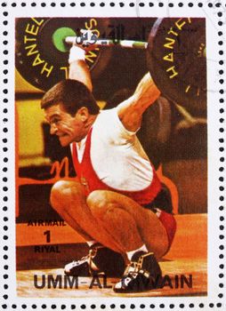 UMM AL-QUWAIN - CIRCA 1972: a stamp printed in the Umm al-Quwain shows Weightlifting, Gymnastics, Summer Olympics, Munich 1972, circa 1972