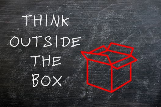 Concept of "Think Outside the box" drawn with chalk on a smudged chalkboard 