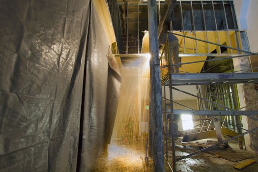 Construction Worker with Blow Torch Welding and Cutting Steel Support on Scaffolding 2