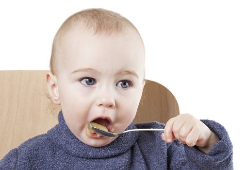 baby eating applesauce - studio shot isolated on white background