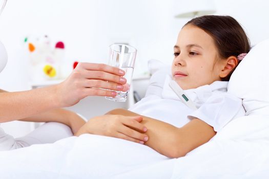 Little girl with illness at bed at home