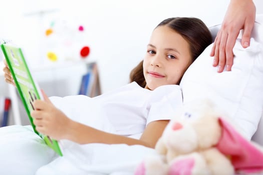 Portrait of girl with a book in bed at home