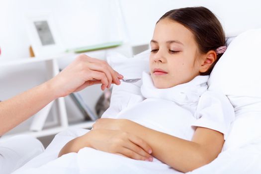 Little girl with illness at bed at home