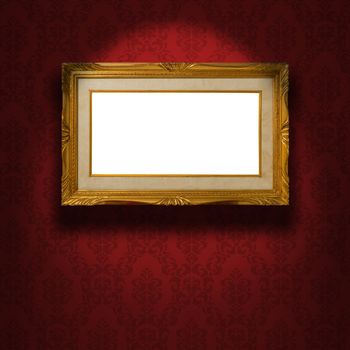Empty golden frame illuminated from a spotlight. The frame is on the red damask wallpaper. Clipping path included.