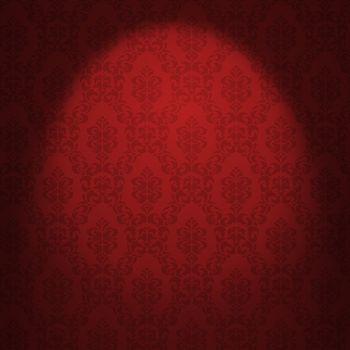 Red damask wallpaper illuminated from a spotlight. 