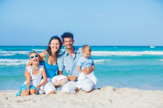 Family of four having fun on tropical beach