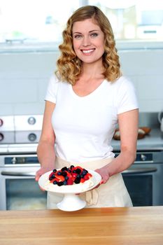 Attractive female presenting yummy treat. Holding bowl and smiling