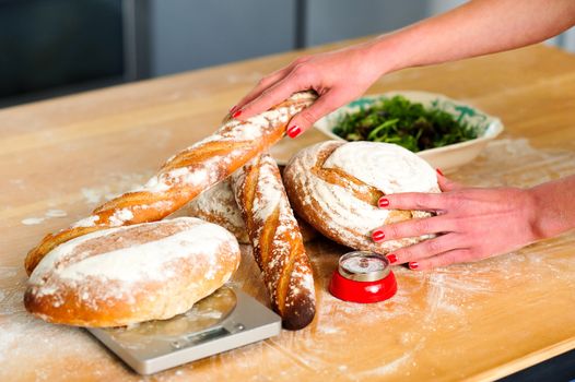 Females hands arranging baguettes and breads. Closeup image