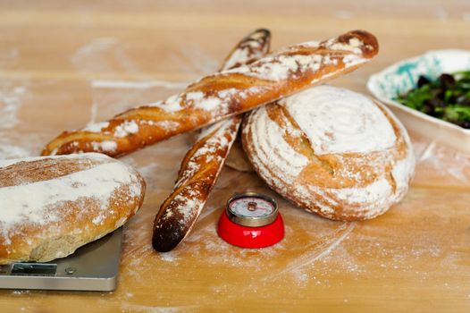 Baguettes and breads on wooden table. Closeup shot