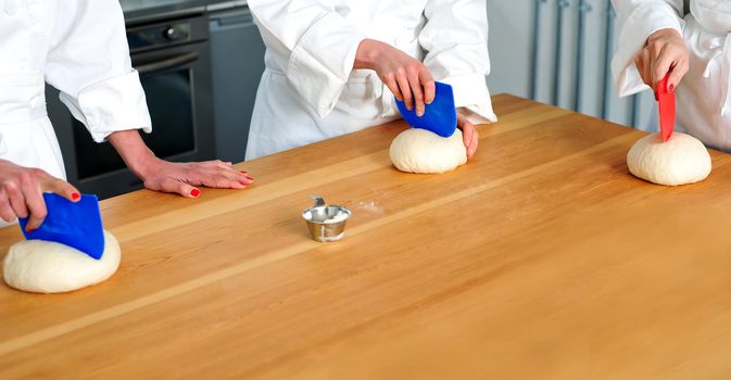 Women hands kneading dough. Bakery preparation