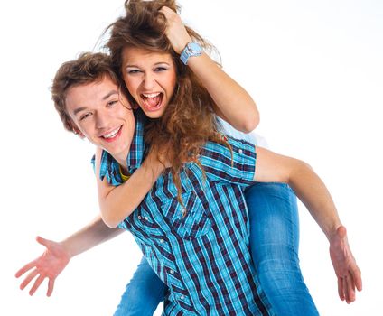 Smiling young man piggybacking his pretty girlfriend. Isolated on white background.