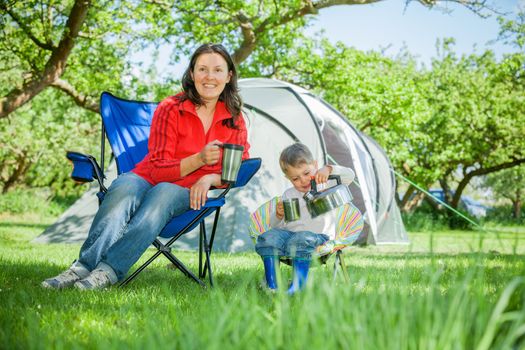 Mother with her son resting in camping great outdoors