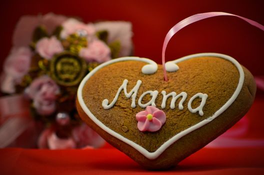 Mothers day gingerbread heart with bouqet in background