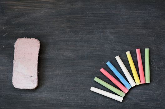 Blank smudged blackboard background with colorful chalk and eraser for text writing and design