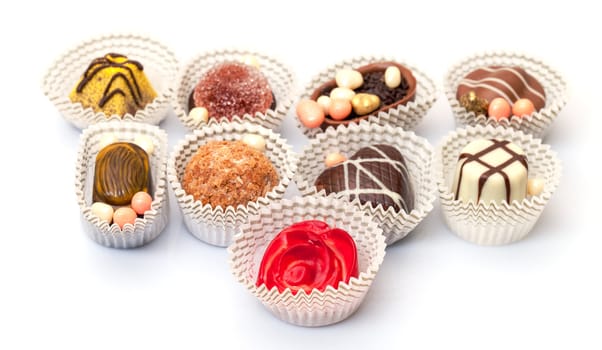 Assorted Chocolates Candy in Paper Basket, closeup on a white background