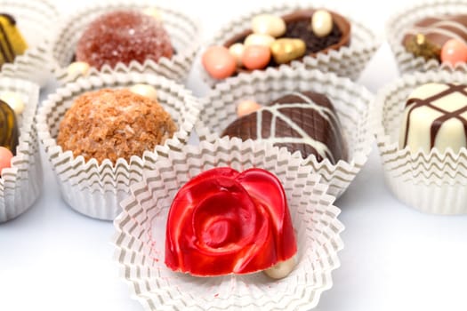 Assorted Chocolates Candy in Paper Basket, closeup on a white background