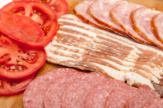 Assorted Slice Sausage, Bacon and Tomato on Cutting Board, closeup