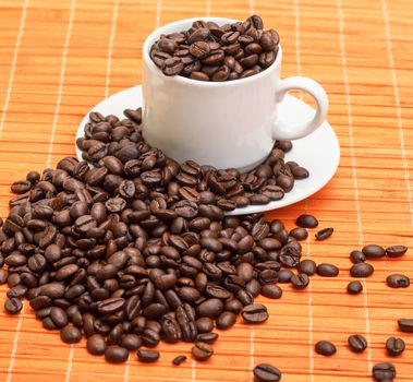 Cup with Coffee Beans on Bamboo Mat