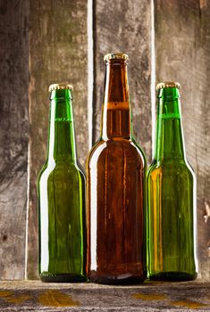 three beer bottle on old wooden plank backbround