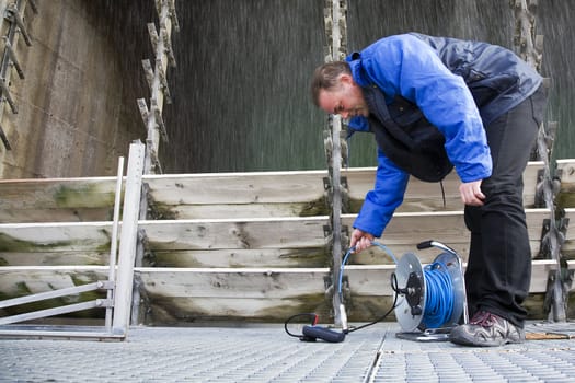 Engineer measuring the basin and hydrostatic level of a cooling tower.