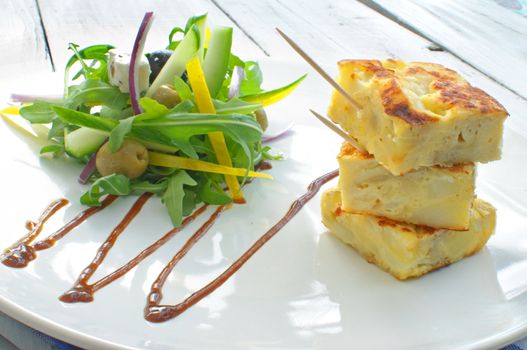 Potato omelette on a plate with a salad 