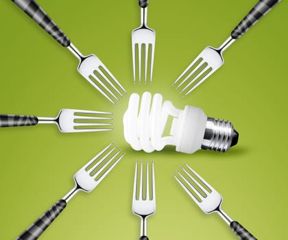 Forks around light bulb, on green background