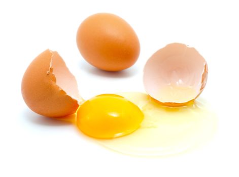 brown eggs on a white background. One egg is broken.