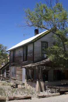 Ramshackle, falling down old wooden house, against a blue sky with copy space.