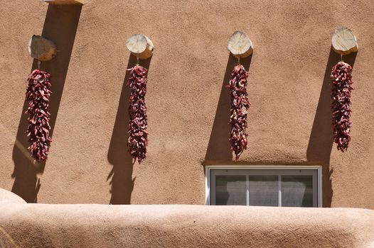 New Mexico adobe building, featuring four chili pepper ristras.
